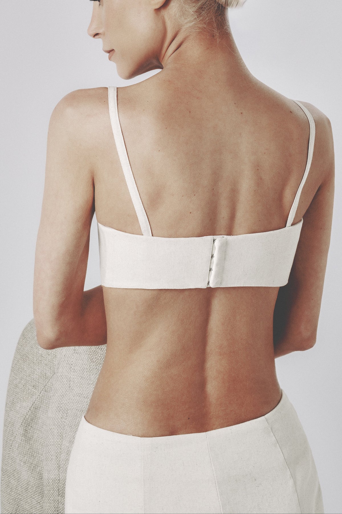 Back detail of the beige bra top showing the adjustable dual-row hook closure