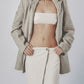 Woman wearing a beige linen cotton maxi skirt with a matching strappy crop top