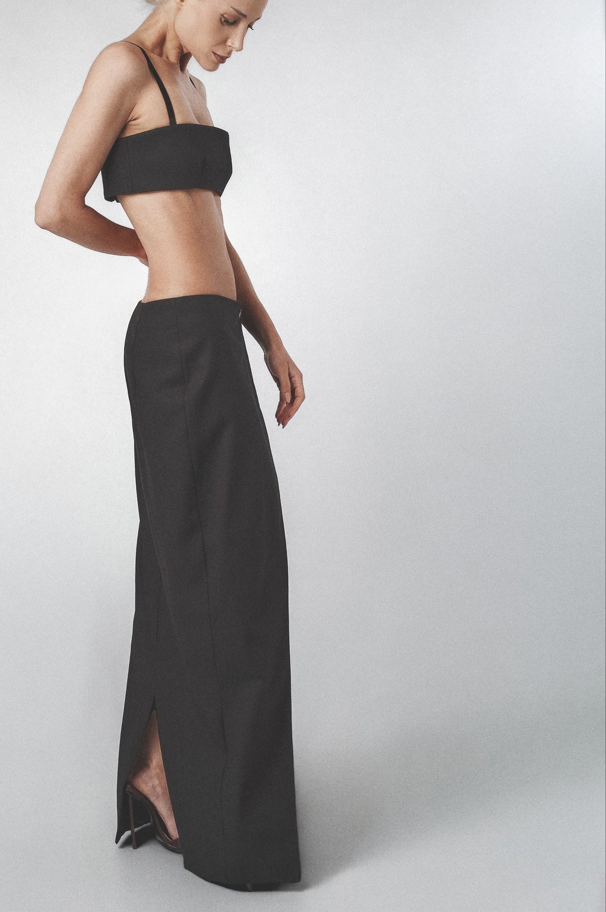 Black structured maxi skirt worn low on the waist with matching bra top