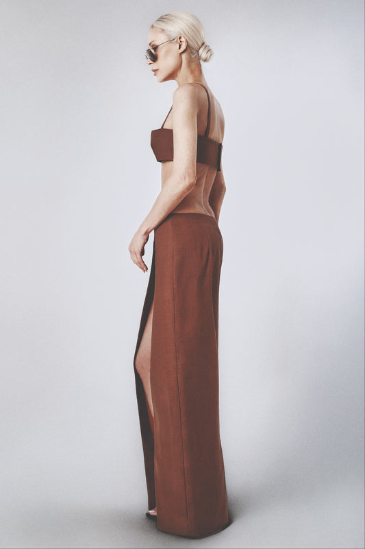 Woman wearing a brown low-waist linen maxi skirt with matching crop top