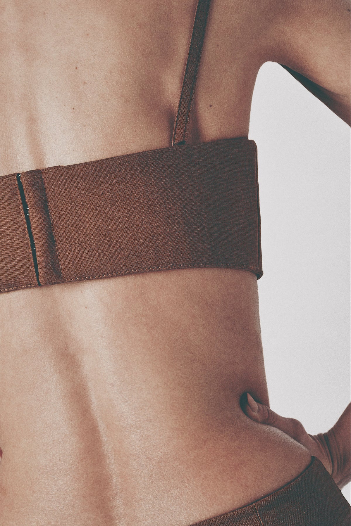 Close-up back view of the brown structured crop top and hook closure