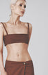 Woman wearing the Cacao brown linen bra crop top with matching low-waist maxi skirt