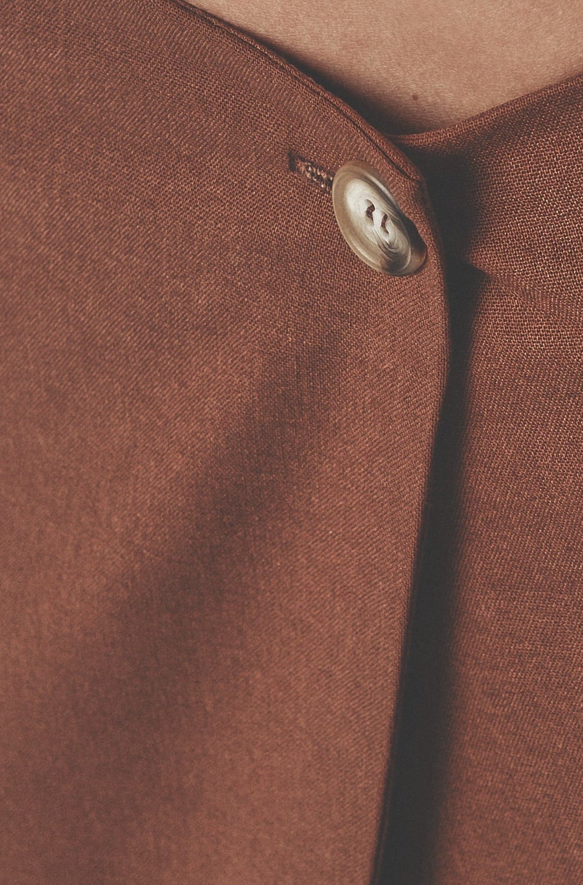 Close-up of the Cacao maxi skirt showing the low waist and front button closure