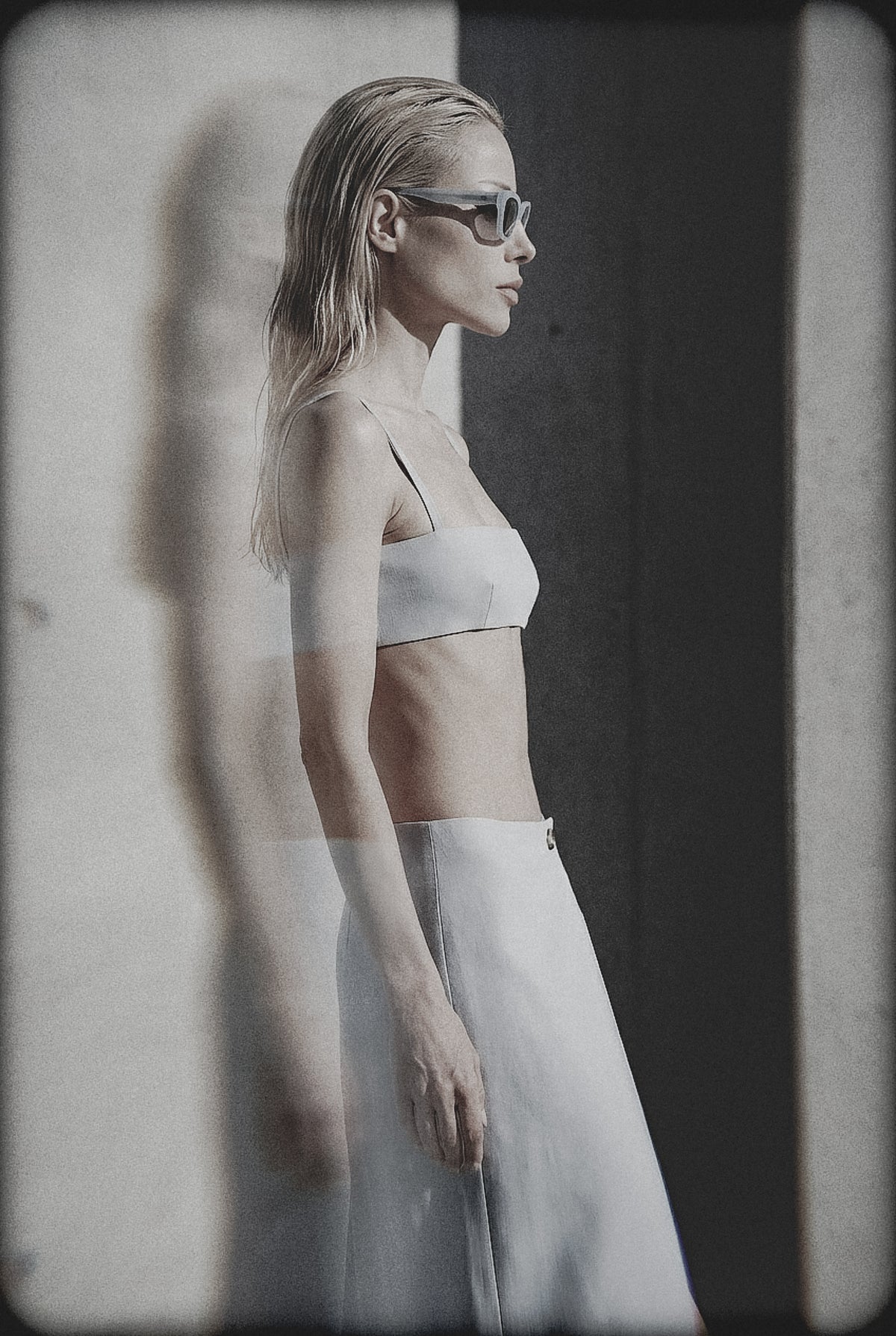 Woman wearing a light blue bra crop top and matching maxi skirt in an editorial image