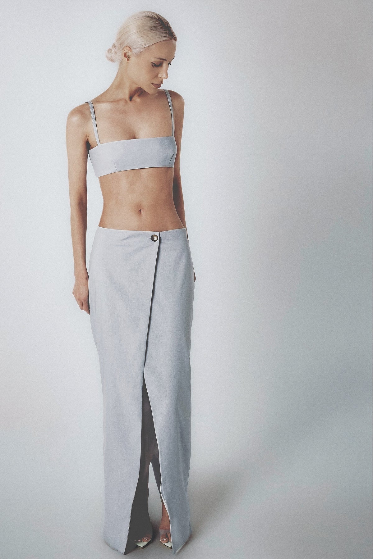 Woman wearing a light blue low-waist maxi skirt with matching crop top