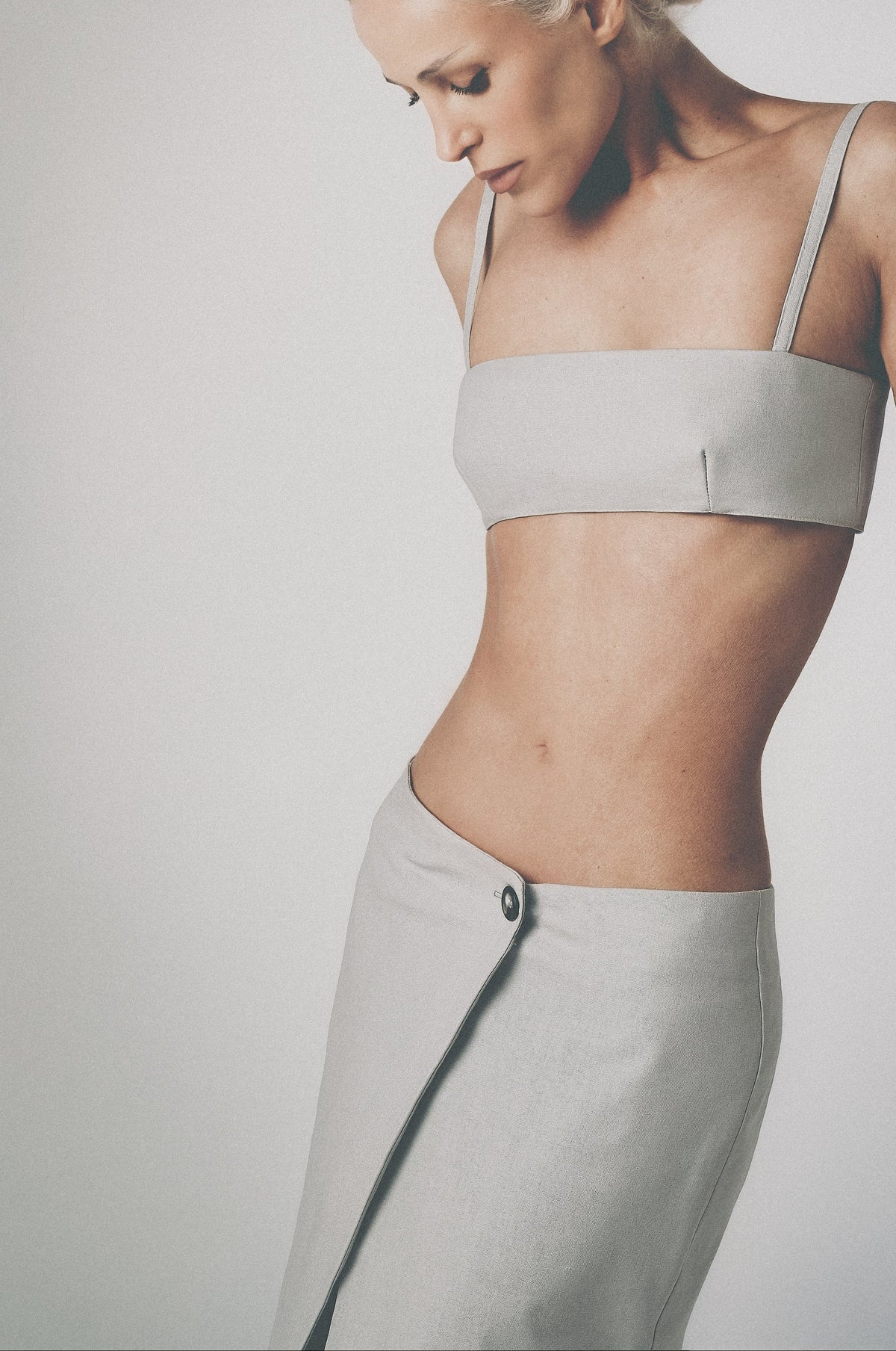 Woman wearing a light grey structured bra crop top with slim straps