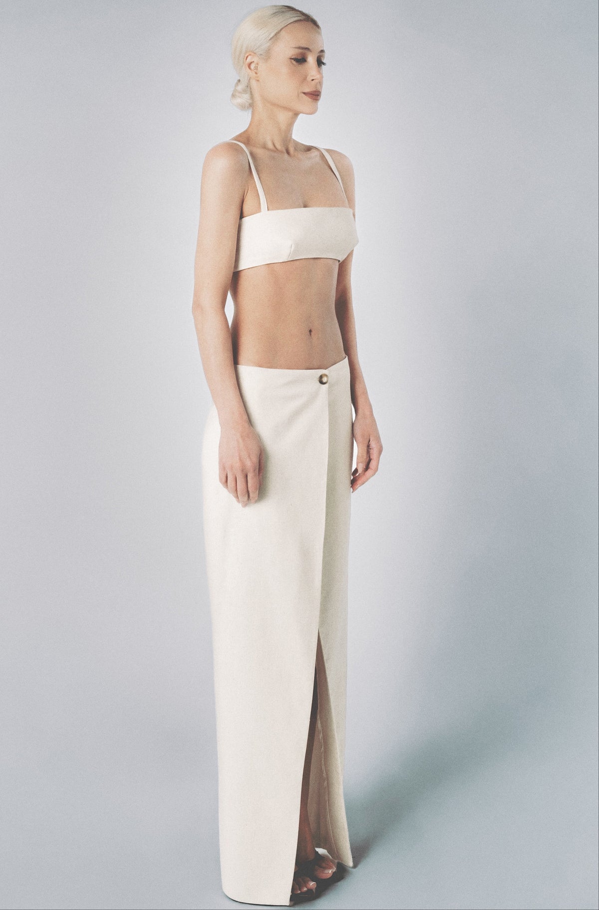 Woman wearing a Sand low-waist linen cotton maxi skirt with matching bra crop top