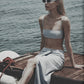 Woman wearing a Sky Blue linen maxi skirt and matching bra top by the water