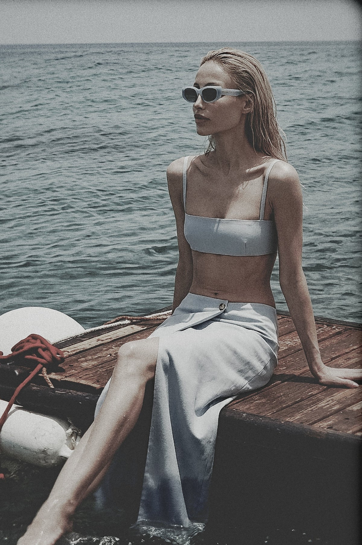 Woman wearing a Sky Blue linen maxi skirt and matching bra top by the water