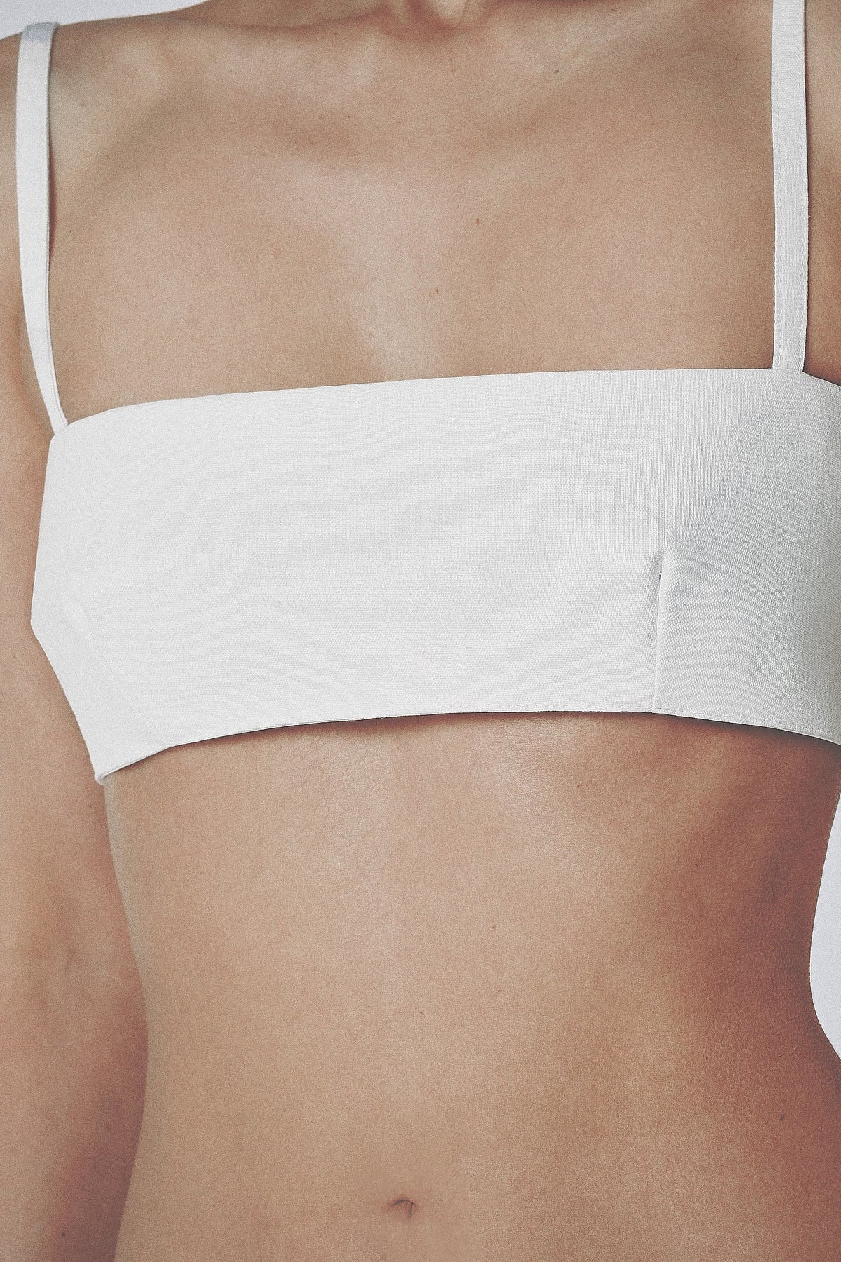 Close-up front view of the White bra crop top with straight neckline and slim straps