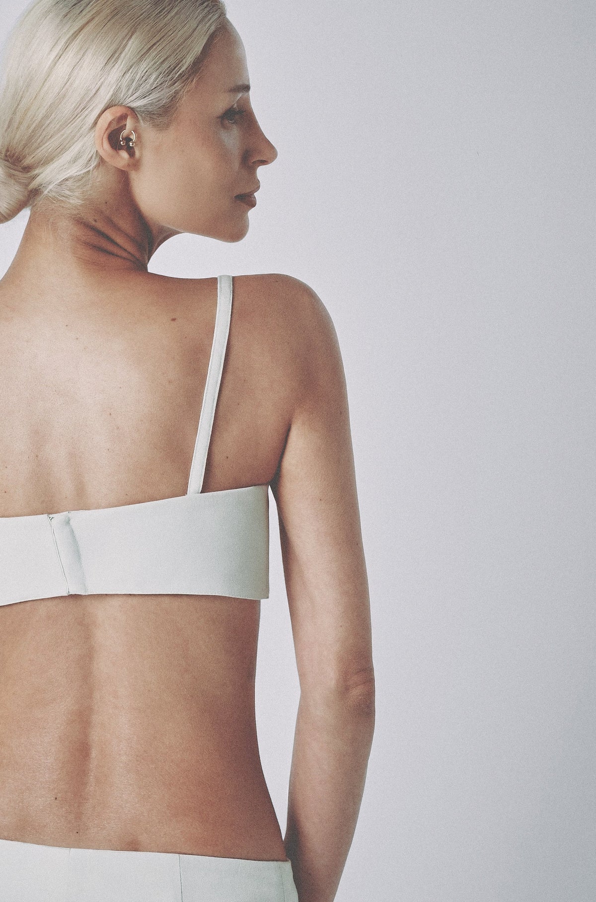 Side profile of the White linen bra top showing its close fit and slim straps