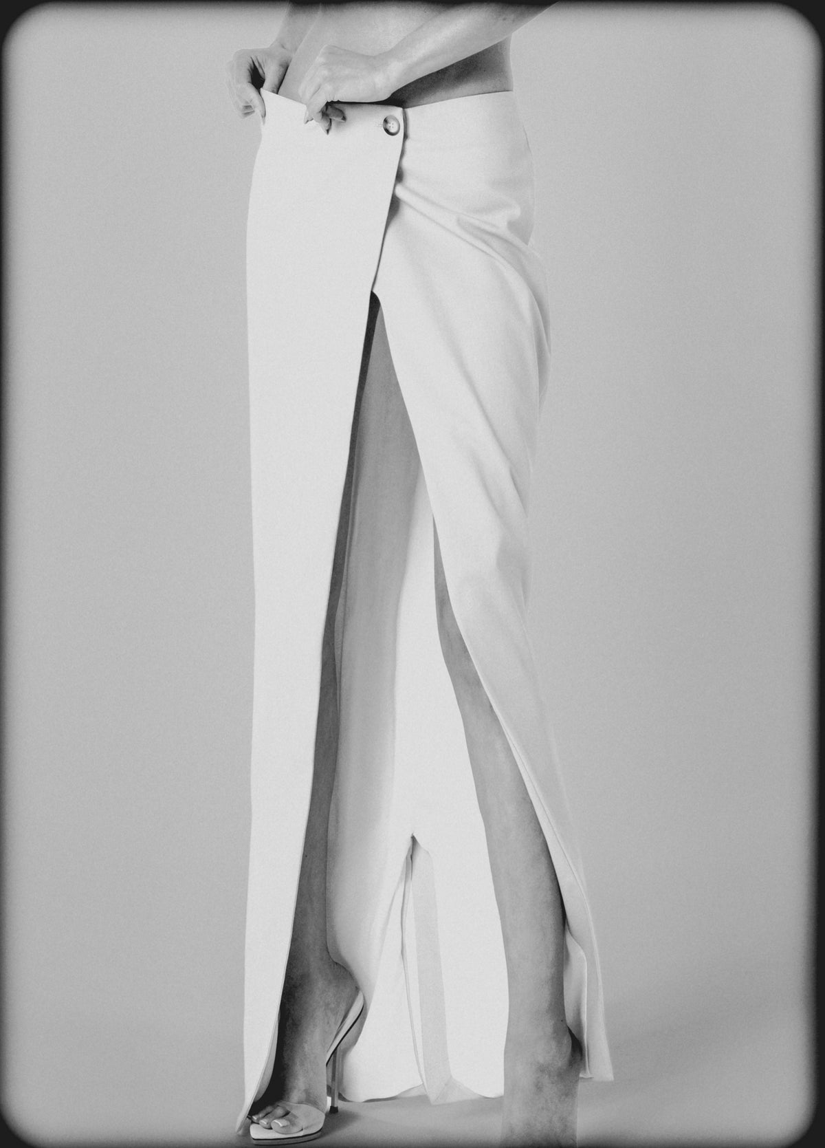 Side view of the White low-rise maxi skirt showing its long straight cut